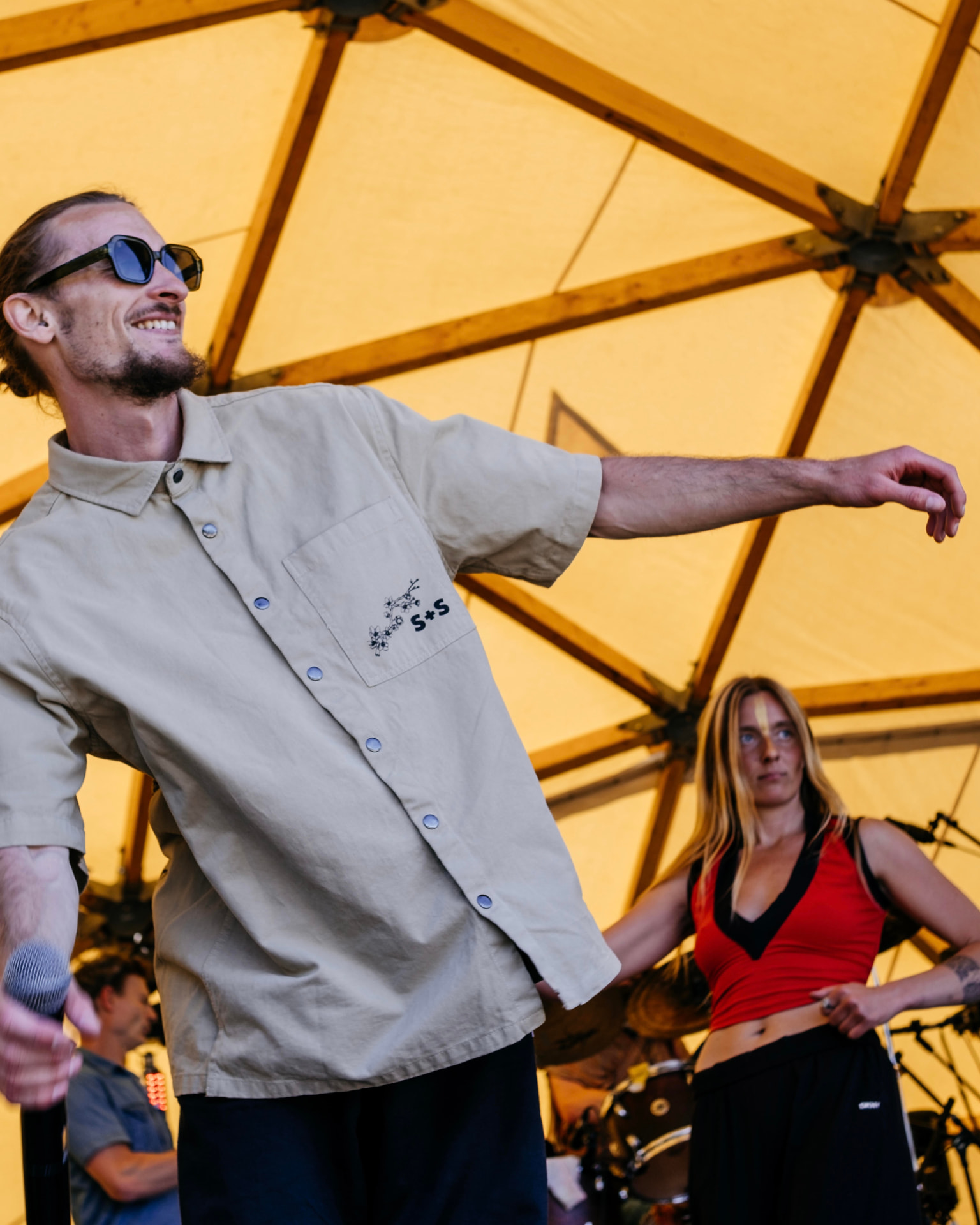 MC and dancer on stage under a festival canopy