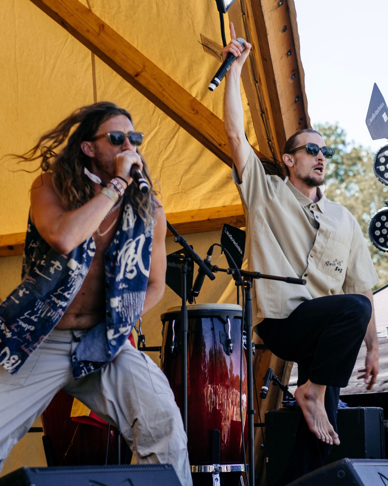 Vocalists and percussionist performing on a festival stage