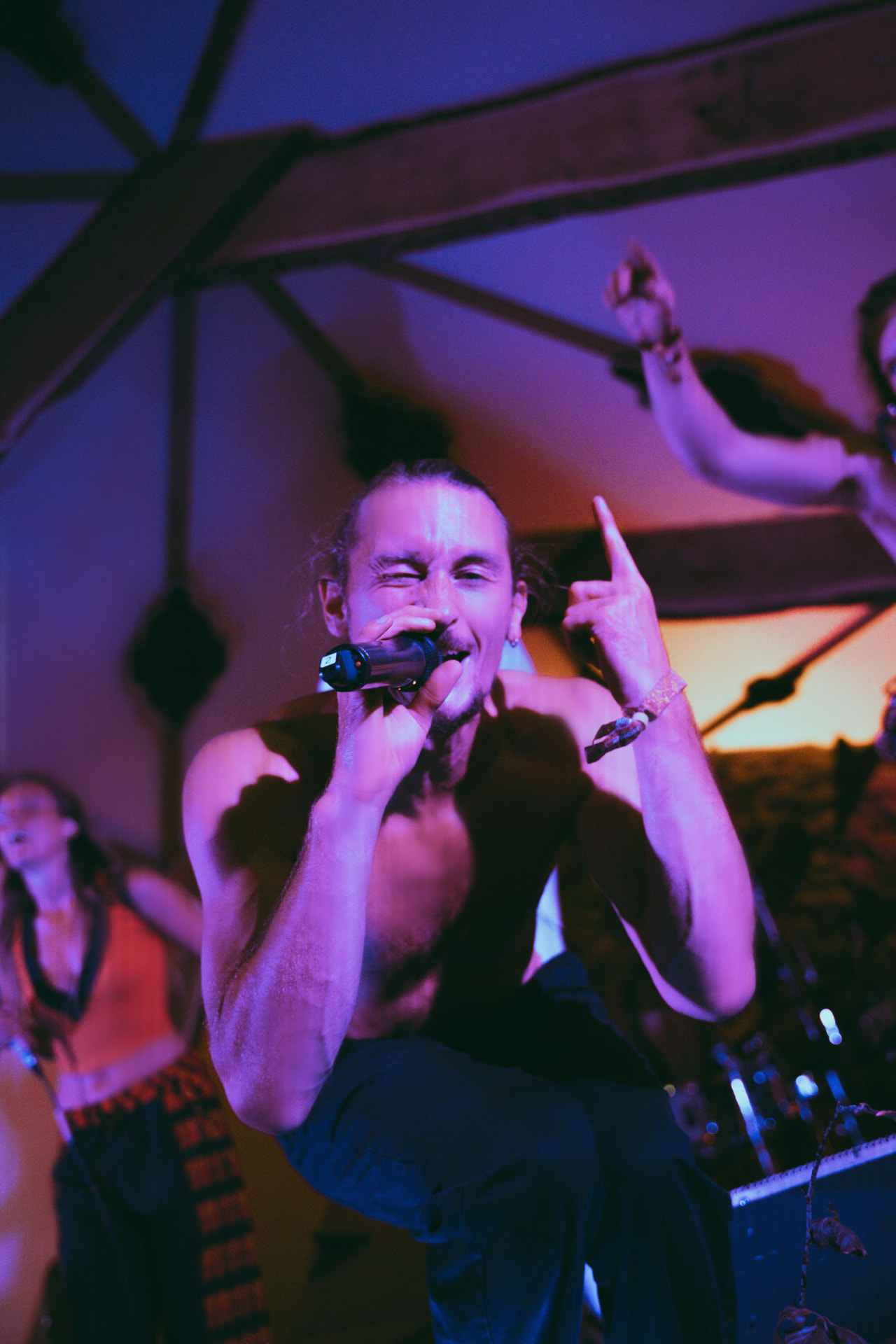 MC crouched on a monitor singing into the microphone
