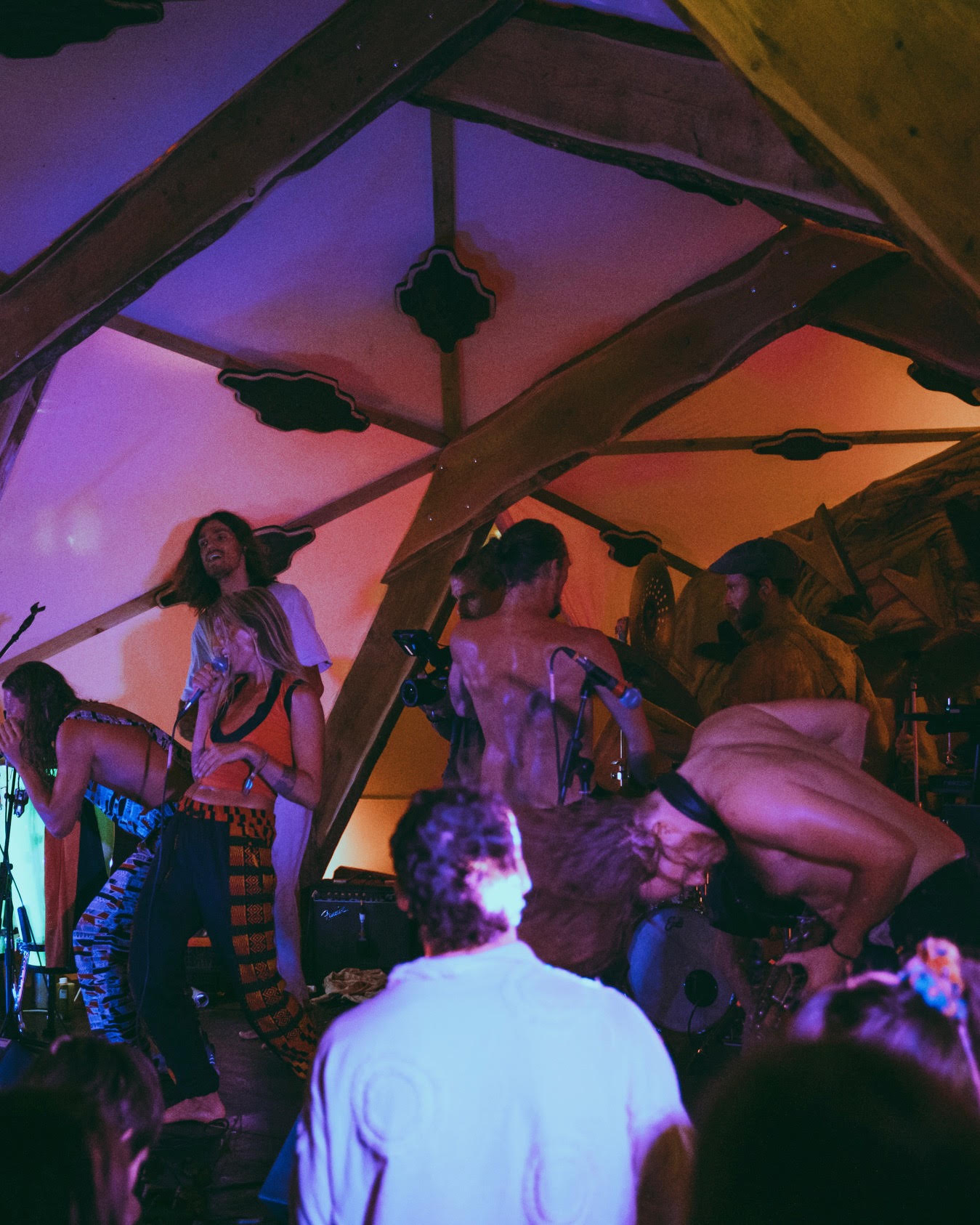 Band members mid-performance with drums and microphones
